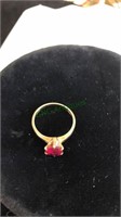 Gold tone ring marked 10K with a Redstone, size 7