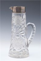 A CIRCA 1900 CUT GLASS TANKARD WITH STERLING