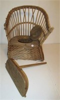 Wicker potty chair with lid over seat. Has desk.