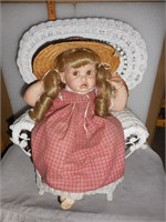 Little Girl sitting in Wicker Chair in plaid dress