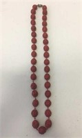 A Chinese cinnabar lacquer beaded necklace