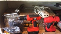 Shelf of tools includes cordless drills, levels,
