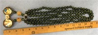 Triple stranded round jade bead necklace with reli