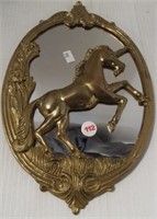 Wall mirror with brass unicorn and frame.