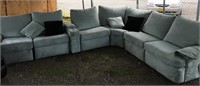 A large mint green sectional sofa with four pillow