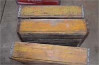 Three yellow wooden Coca Cola crates