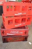 Four plastic Coca-Cola crates