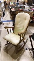 Maple rocking chair with a light yellow cushions,