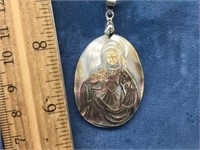 A sacred heart of Mary abalone pendant on a sterli