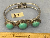 A silver alloy, hinged bracelet with faux turquois