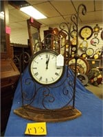 Iron stands with clock on wood base