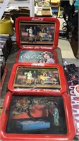 Three Coca-Cola trays one is it lap tray and one