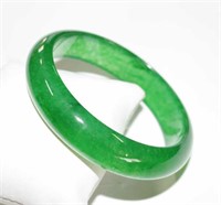 Solid green jade bangle in a half dome shape,