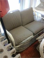 White cushioned outdoor loveseat 1 ripped cushion