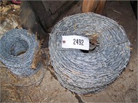 1 NEW ROLL OF BARB WIRE & 1 PARTIAL ROLL.