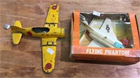 Two toy airplanes, one is a flying phantom in the