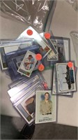 Group of trading cards in plastic cases including