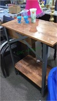 Tall metal and wood top work table with one shelf