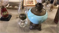 Two antique oil lamps one with a light turquoise