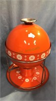 Retro fondue pot in the bright orange color with