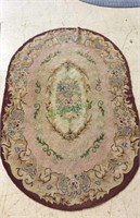 Vintage oval hooked rug with rose and burgundy