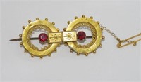 18ct yellow gold and purple-red stone brooch