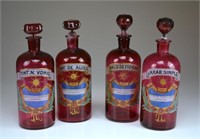 Four cranberry glass apothecary jars
