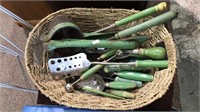 Basket of green handled utensils for the kitchen,
