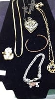 Six pieces of vintage jewelry, including a dog