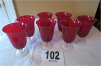 7 large ruby colored stemware glasses.
