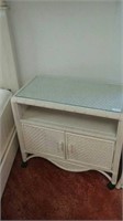 White wooden and wicker glass top rolling cabinet