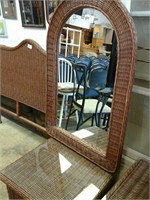 Brown wicker framed arched mirror