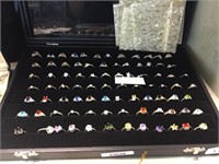 84 ASSORTED RINGS IN DISPLAY CASE