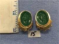 A pair of 1" jade earrings with carved faces