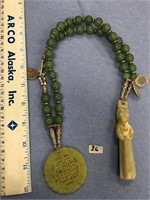 A very unusual jade necklace with a few carved pen