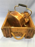 A wood box with a copper tea pot and cooking kettl
