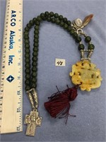 A very unusual jade necklace with a few carved pen