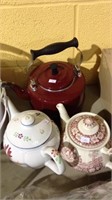 One metal tea kettle and two ceramic teapot with