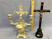 Metal holy water font with candles and a Crucifix