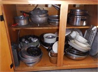 Lower double door cabinet full of pots and pa