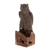 Metal owl sculpture on wood stand