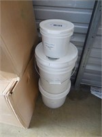 Three plastic tubs of material