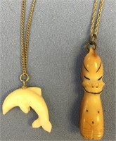 Two ivory pendants on chain - one is a Billiken on