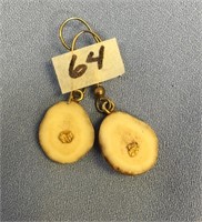 A pair of ivory earrings with small gold nuggets