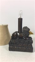 Small desk lamp with lion on top of books
