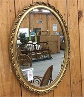 Oval mirror in decorative gold colored frame