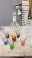 GLASS DECANTER AND 6 COLORED SHOT GLASSES