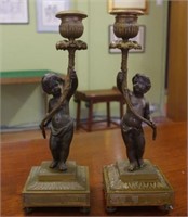 Pair of antique bronze putti candlesticks