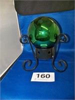 Green gazing ball on low metal base
