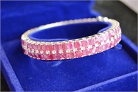 An ornate ladies ruby bangle, set with 98